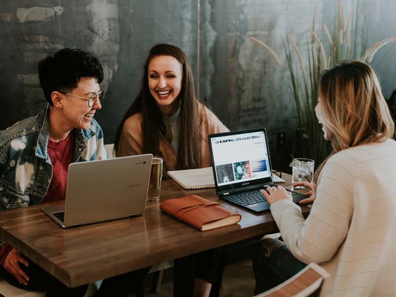 People looking at laptop and smiling